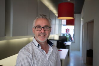 Glimlachende man in kantooromgeving.