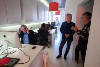 Kantooromgeving met werkende en pratende collega's.