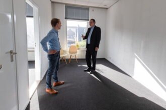 Twee mannen in gesprek op kantoor.
