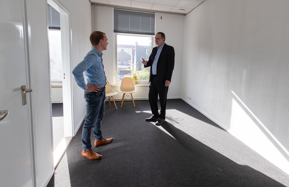 Twee mannen in gesprek op kantoor.