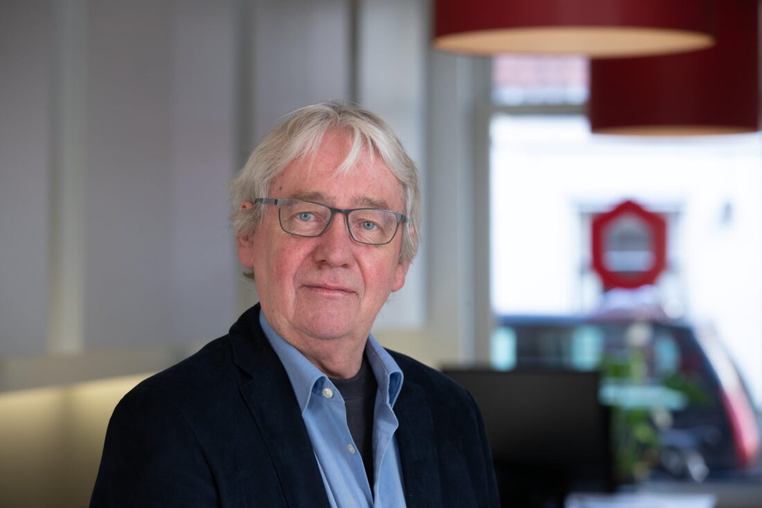 Oudere man in pak binnen kantooromgeving