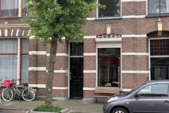 Traditioneel Nederlands bakstenen huis met fietsen ervoor.
