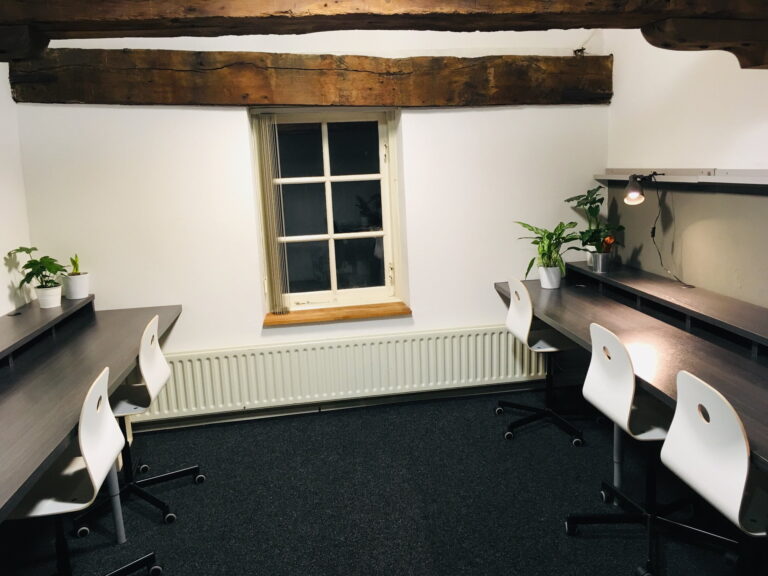 Moderne vergaderruimte met houten balken en planten.