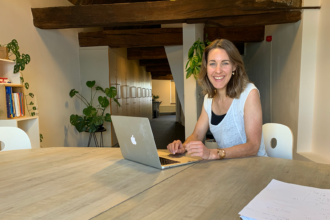 Vrouw werkt op laptop in modern kantoor.