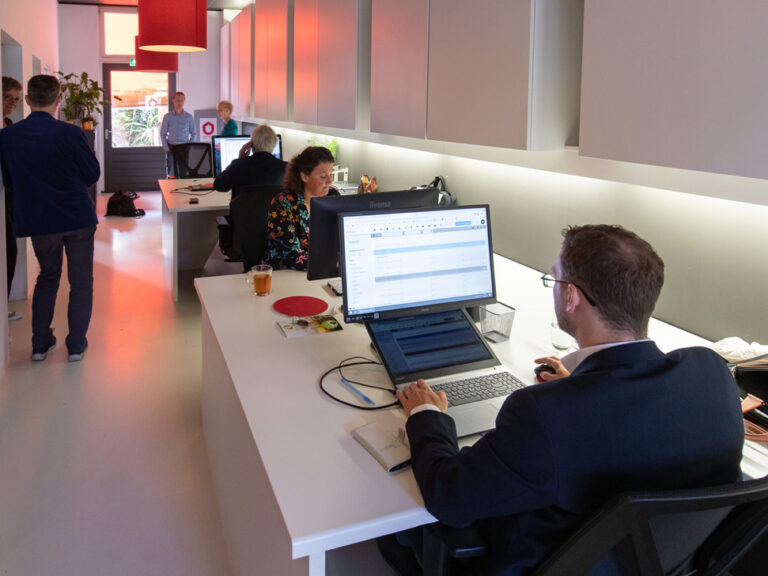 Mensen werken in modern kantoor met computers.